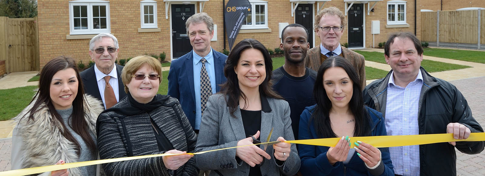 CHS Board Chair Heidi Allen cutting ribbon to open new homes