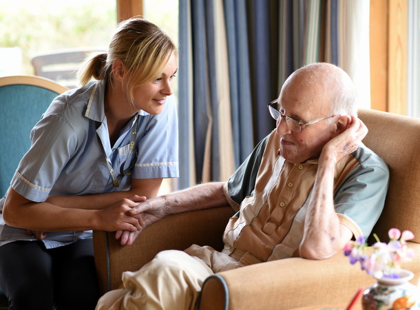 CHS carer supporting elder resident in care home