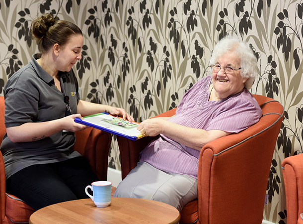 Care home staff interacting with elderly resident