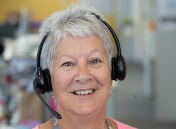 Smiling older CHS Customer Service Advisor - looking at camera