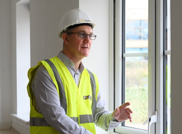 White male CHS surveyor looking at window wall