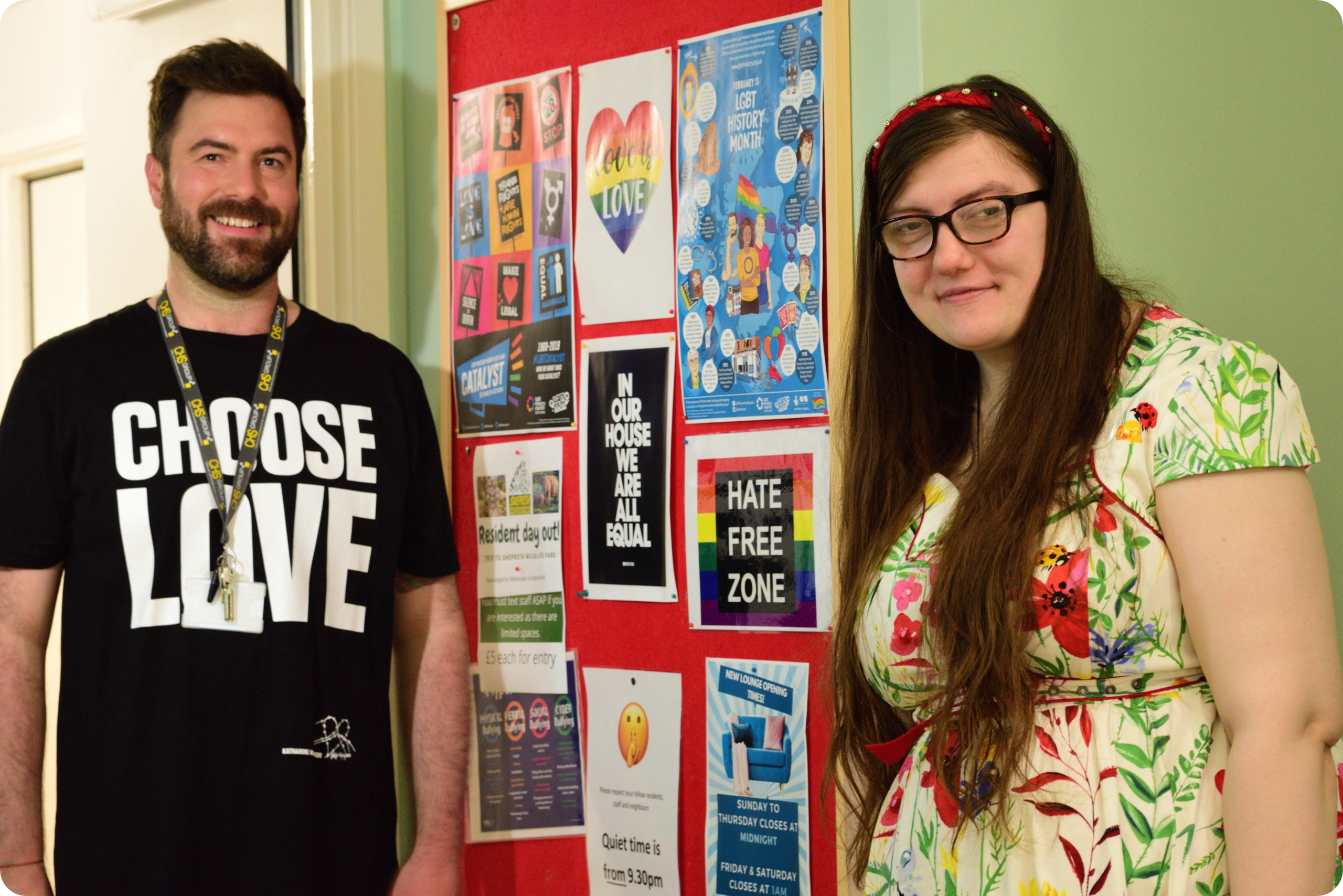 Male support worker with female resident in front of display board promoting Equality Diversion and Inclusion scaled