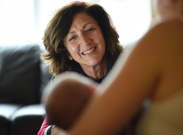 Female support worker talking to young mum holding her baby